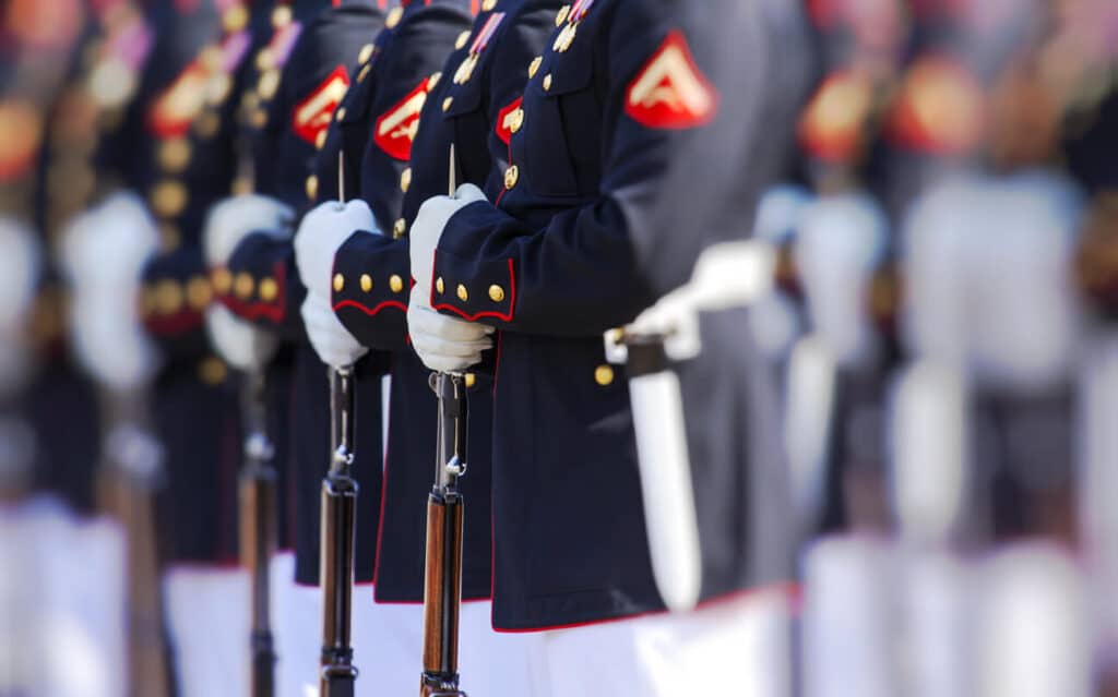 United States Marines standing in a line while holding their rifles.