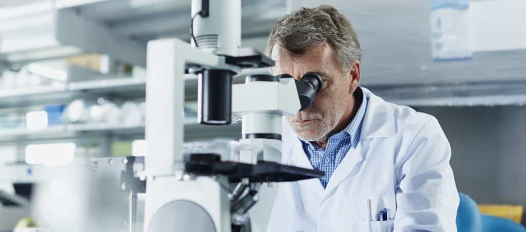 Scientist looking through microscrope