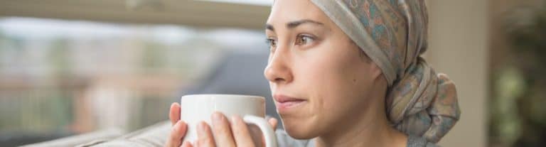 Worried cancer patient holding a coffee mug
