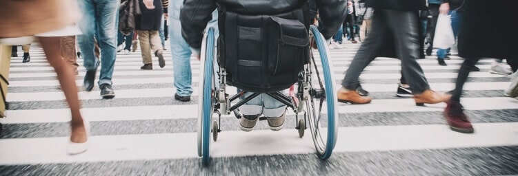 Man in wheelchair on crosswalk.
